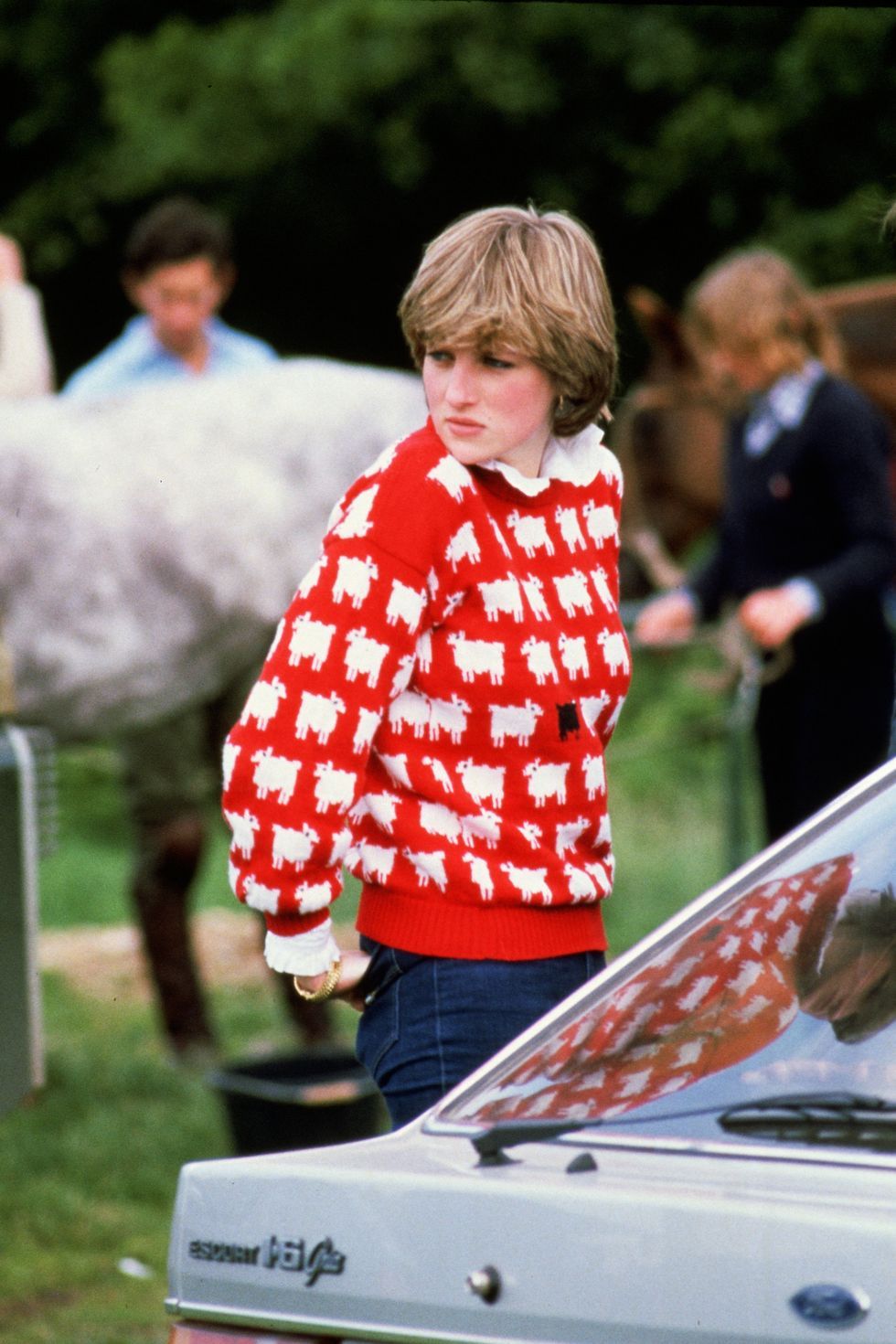 Princess Diana at the Windsor Polo match in 1980 wore a warm red sweater with a goat pattern.  She looks so stunning!  (photo: oprahdaily.com)