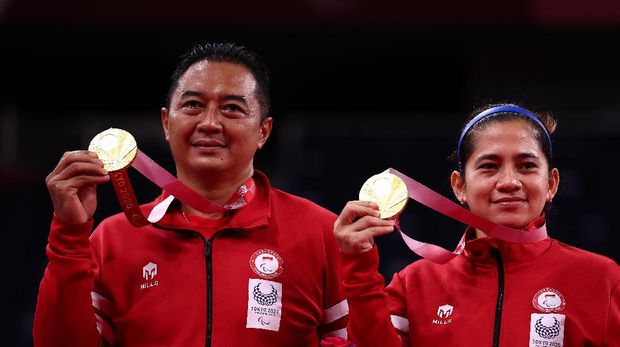 Hary/Leani Raih Emas Tokyo 2020 Paralympic Games - Badminton - Mixed Doubles SL3-SU5 Medal Ceremony - Yoyogi National Stadium, Tokyo, Japan - September 5, 2021. Gold medallists Hary Susanto of Indonesia and Leani Ratri Oktila of Indonesia pose on the podium REUTERS/Athit Perawongmetha