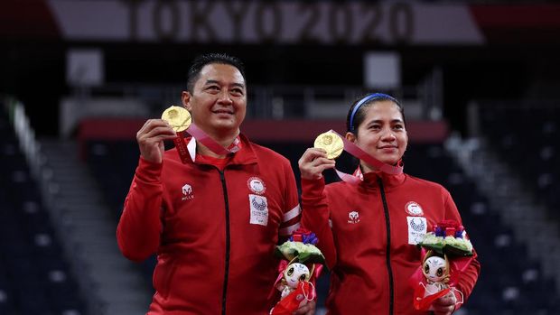 TOKYO, JAPAN - SEPTEMBER 05: Gold medalist Susanto Hary and Oktila Leani Ratri of Team Indonesia pose on the podium at the medal ceremony for the Mixed Doubles SL3-SU5 on day 12 of the Tokyo 2020 Paralympic Games at Yoyogi National Gymnasium on September 05, 2021 in Tokyo, Japan. (Photo by Kiyoshi Ota/Getty Images)