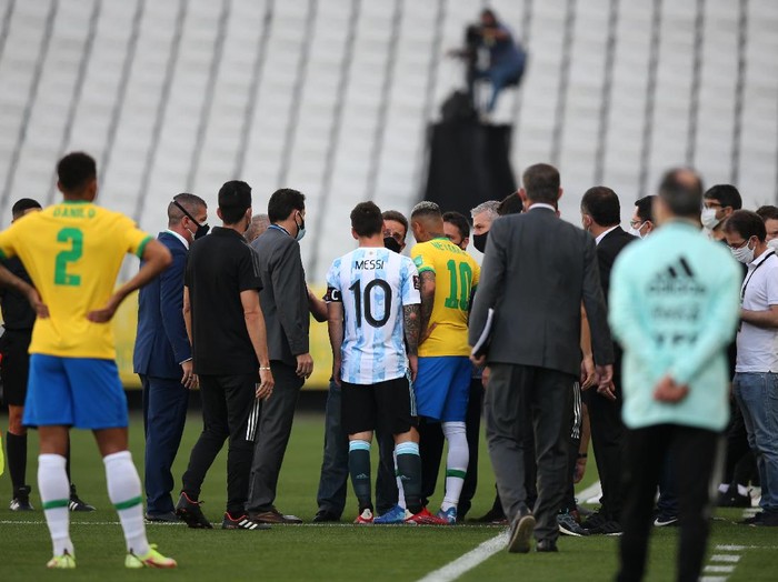 SAO PAULO, BRAZIL - SEPTEMBER 05: Lionel Messi of Argentina and Neymar Jr. of Brazil talk to health authorities as the match is delayed during a match between Brazil and Argentina as part of South American Qualifiers for Qatar 2022 at Arena Corinthians on September 05, 2021 in Sao Paulo, Brazil. (Photo by Alexandre Schneider/Getty Images)