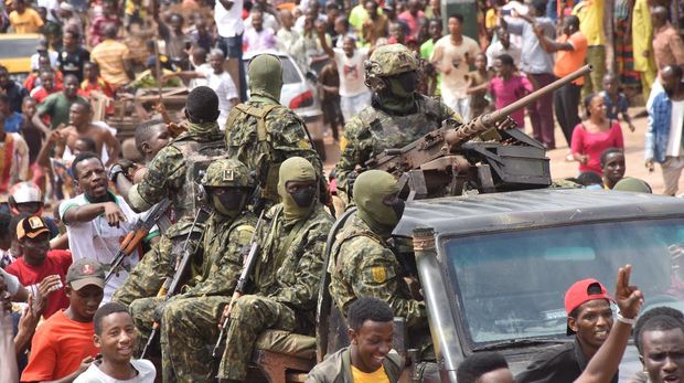 People celebrate in the streets with members of Guinea's armed forces after the arrest of Guinea's president, Alpha Conde, in a coup d'etat in Conakry, September 5, 2021. - Guinean special forces seized power in a coup on September 5, arresting the president and imposing an indefinite curfew in the poor west African country. 
