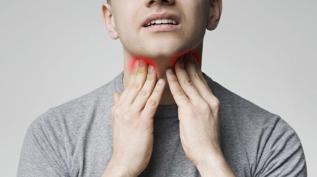 Breathing problem. Young man pulping his inflamed neck, close up