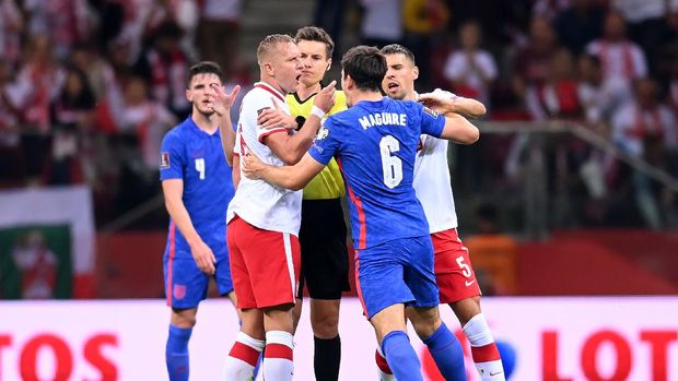 WARSAW, POLAND - SEPTEMBER 08:  Harry Maguire of England clashes with Kamil Glik and Jan Bednarek of Poland during the 2022 FIFA World Cup Qualifier match between Poland and England at Stadion Narodowy on September 08, 2021 in Warsaw, Poland. (Photo by Michael Regan/Getty Images)