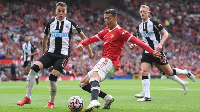 MANCHESTER, ENGLAND - SEPTEMBER 11: Cristiano Ronaldo of Manchester United shoots whilst under pressure from Javier Manquillo of Newcastle United during the Premier League match between Manchester United and Newcastle United at Old Trafford on September 11, 2021 in Manchester, England. (Photo by Laurence Griffiths/Getty Images)