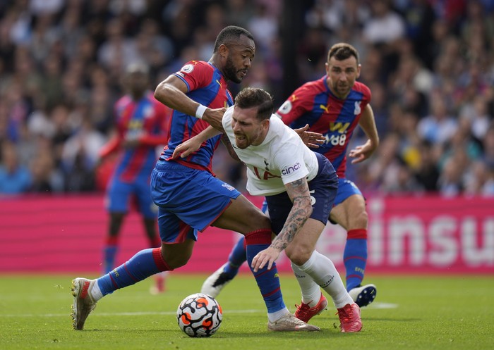Crystal Palaces Jordan Ayew, left, and Tottenhams Pierre-Emile Hojbjerg challenge for the ball during the English Premier League soccer match between Tottenham Hotspur and Crystal Palace at the Selhurst Park stadium in London, Saturday, Sept. 11, 2021. (AP Photo/Alastair Grant)