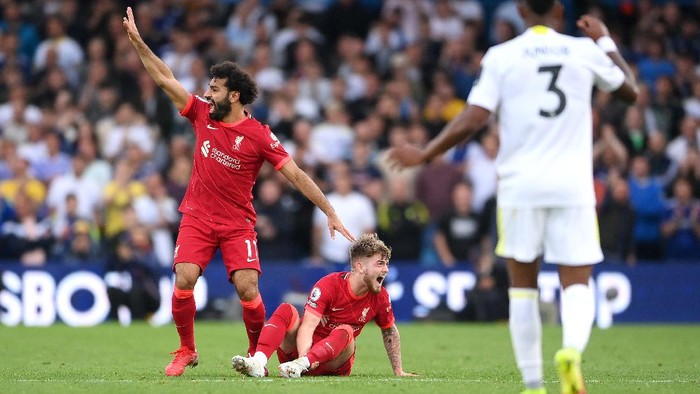 Liga Inggris LEEDS, ENGLAND - SEPTEMBER 12: Harvey Elliott of Liverpool reacts as he looks to be injured as Mohamed Salah of Liverpool calls for medical attention during the Premier League match between Leeds United and Liverpool at Elland Road on September 12, 2021 in Leeds, England. (Photo by Laurence Griffiths/Getty Images)