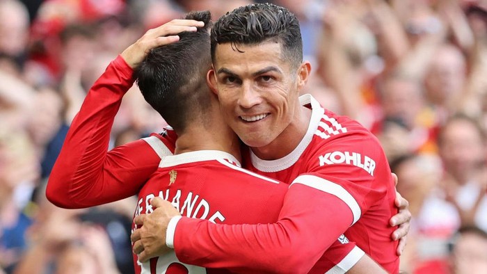 MANCHESTER, ENGLAND - SEPTEMBER 11: Bruno Fernandes of Manchester United celebrates with Cristiano Ronaldo after scoring their sides third goal during the Premier League match between Manchester United and Newcastle United at Old Trafford on September 11, 2021 in Manchester, England. (Photo by Clive Brunskill/Getty Images)