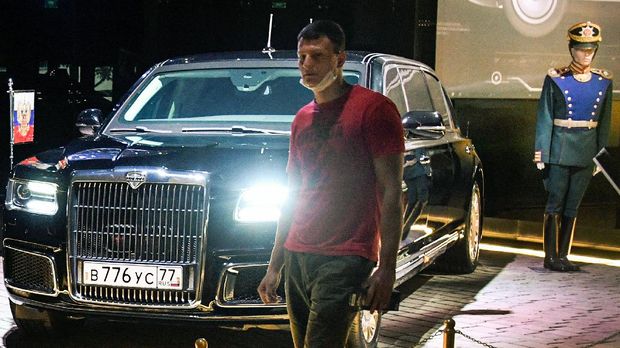 A man walks past Aurus Senat - a personal vehicle of Russian President Vladimir Putin since May 2018 in a Museum of the Special Task Garage of the Federal Guard Service (FSO) in Moscow on September 14, 2021. - The museum was opened to mark the 100th anniversary of the establishment of the Special Task Garage of the Federal Guard Service (FSO) of the Russian Federation, carrying a transportation duty of the leaders of the state, which will be not only the main custodian of the history of the legendary unit, but also a centre for studying and promoting the achievements of domestic and global automotive industry. (Photo by Alexander NEMENOV / AFP)