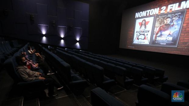 Pengunjung membeli tiket saat akan menonton bioskop di CGV Central Park, Jakarta, Kamis (16/9/2021). Pemerintah telah mengumumkan bioskop boleh kembali beroperasi untuk wilayah yang berada di level 2-3 PPKM di wilayah Jawa-Bali maupun luar Jawa-Bali. Pemprov DKI Jakarta hari ini melakukan uji coba pembukaan bioskop selama penerapan pemberlakuan pembatasan kegiatan masyarakat (PPKM) level 3. Uji coba dilakukan di seluruh bioskop di Jakarta. Pembukaan bisokop tersebut harus menerapkan protokol kesehatan yang ketat. Pengunjung yang datang harus menyiapkan aplikasi dan akun PeduliLindungi. Saat akan masuk, ada ketentuan scan QR Code di pintu masuk Platinum, kemudian klik check-in. Begitu pun saat keluar pengunjung harus meng-klik check-out di aplikasi. Selain menggunakan aplikasi PeduliLindung pengunjung yang datang wajib sudah vaksin dua kali, berusia 12 tahun keatas serta maksimal kapasitas 50% tanpa makan dan minum di dalam ruangan. Aturan ini sesuai dengan Keputusan Gubernur (Kepgub) Nomor 1096 Tahun 2021 tentang PPKM Level 3. Kepgub tersebut ditandatangani Gubernur Anies Baswedan pada 13 September 2021. Di bisokop yang berlokasi di Central Park ini, menayangkan beragam film favorit seperti Black Widow, Shang-Chi, Malignant, The Suicide Squad, Free Guy, Snake Eyes, Space jam, Stillwater, Hard Hit, Escape From Mogadishu, Blackpink : The Movie. Dari pantau di lokasi, pengunjung yang datang untuk menonton masih sepi. Pasa sore hari ini pengunjung yang menonton di dalam studio tidak lebih dari 10 orang. Sebelumnya pada tanggal 5 Juli 2021, bioskop sempat berhenti beroperasi menyesuaikan regulasi PPKM guna menekan jumlah penyebaran Covid-19 yang semakin meluas. (pojokdepok.com/Andrean Kristianto)
