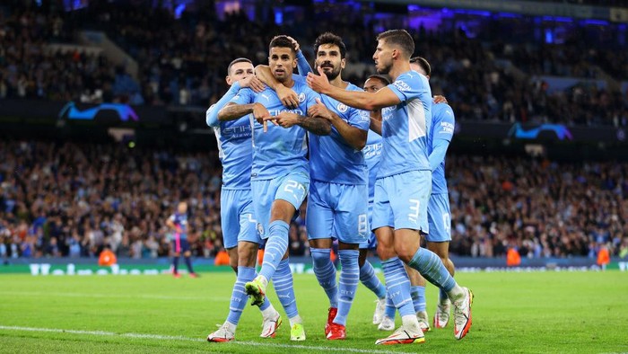 MANCHESTER, ENGLAND - SEPTEMBER 15: Joao Cancelo of Manchester City celebrates with teammates Phil Foden and Ilkay Guendogan and Ruben Dias after scoring their sides fifth goal during the UEFA Champions League group A match between Manchester City and RB Leipzig at Etihad Stadium on September 15, 2021 in Manchester, England. (Photo by Richard Heathcote/Getty Images)