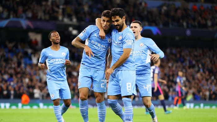 MANCHESTER, ENGLAND - SEPTEMBER 15: Joao Cancelo of Manchester City celebrates with teammate Ilkay Guendogan after scoring their sides fifth goal during the UEFA Champions League group A match between Manchester City and RB Leipzig at Etihad Stadium on September 15, 2021 in Manchester, England. (Photo by Richard Heathcote/Getty Images)