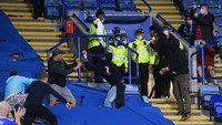 Terlihat suporter kalang kabut kala polisi datang menerjang. (Foto: Laurence Griffiths/Getty Images)