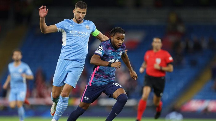 MANCHESTER, ENGLAND - SEPTEMBER 15: Christopher Nkunku of RB Leipzig is challenged by Ruben Dias of Manchester City during the UEFA Champions League group A match between Manchester City and RB Leipzig at Etihad Stadium on September 15, 2021 in Manchester, England. (Photo by Richard Heathcote/Getty Images)