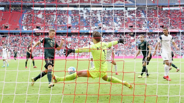 MUNICH, GERMANY - SEPTEMBER 18: Joshua Kimmich (L) of FC Bayern Muenchen scores his second goal against goalkeeper Manuel Riemann of Bochum during the Bundesliga match between FC Bayern München and VfL Bochum at Allianz Arena on September 18, 2021 in Munich, Germany. (Photo by Alexander Hassenstein/Getty Images)