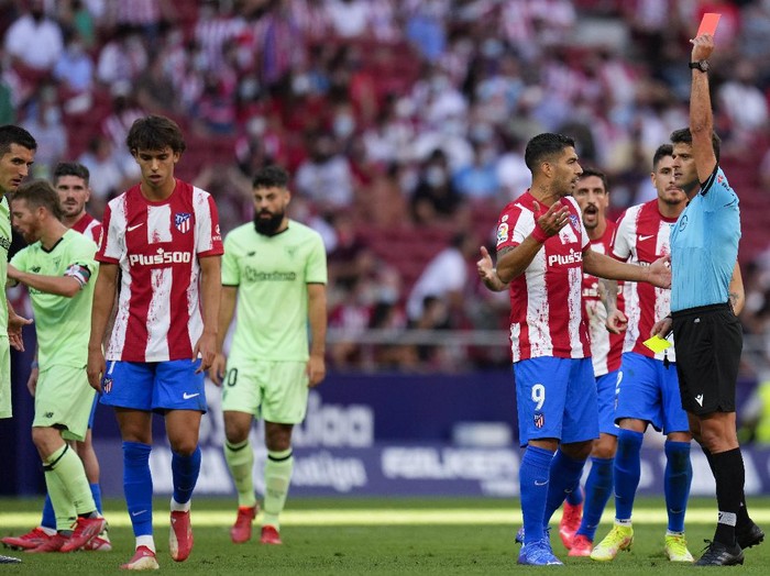 Atletico Madrids Joao Felix, left, is shown the red card during a Spanish La Liga soccer match between Atletico Madrid and Athletic Bilbao at Wanda Metropolitano stadium in Madrid, Spain, Saturday, Sept. 18, 2021. (AP Photo/Manu Fernandez)