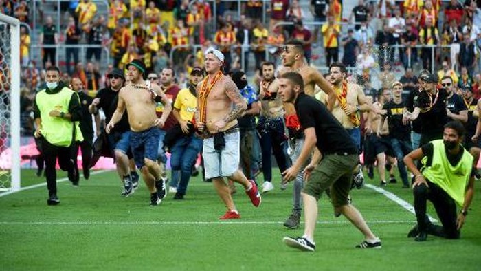 Lens supporters invade the pitch during the French L1 football match between RC Lens (RCL) and Lille (LOSC) at Stade Bollaert-Delelis in Lens, northern France, on September 18, 2021. (Photo by FRANCOIS LO PRESTI / AFP)
