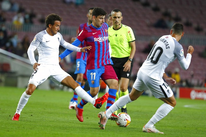 Granadas Luis Milla, left, challenges for the ball with Barcelonas Yusuf Demir during the Spanish La Liga soccer match between Barcelona and Granada, at the Camp Nou stadium in Barcelona, Spain, Monday, Sept. 20, 2021. (AP Photo/Joan Monfort)