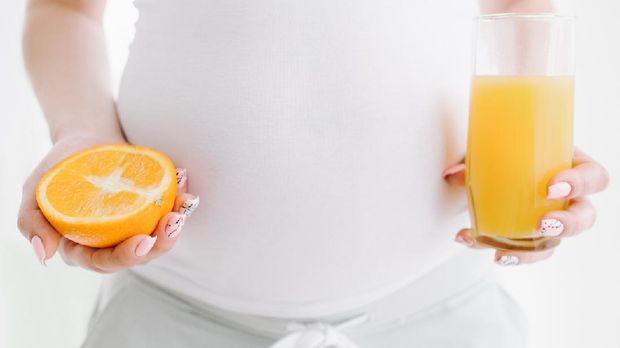 Ilustrasi ibu hamil makan jeruk atau vitamin c