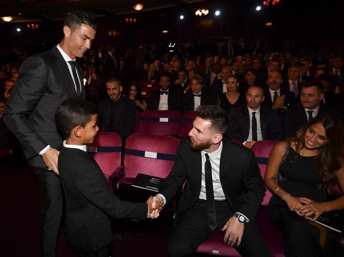 Nominee for the Best FIFA football player, Barcelona and Argentina forward Lionel Messi (2nd R) shakes hands with Cristiano Ronaldo Jr, son of Real Madrid and Portugal forward Cristiano Ronaldo (L) before The Best FIFA Football Awards ceremony, on October 23, 2017 in London. (Photo by Ben STANSALL / AFP)