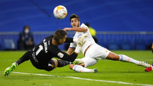 Real Madrid's Marco Asensio kicks the ball past Mallorca's goalkeeper Manolo Reina to score his team's third goal during a Spanish La Liga soccer match between Real Madrid and Mallorca at the Bernabeu stadium in Madrid, Spain, Wednesday, Sept. 22, 2021. (AP Photo/Manu Fernandez)