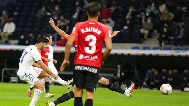 Real Madrid's Marco Asensio, left, scores his team's fourth goal during a Spanish La Liga soccer match between Real Madrid and Mallorca at the Bernabeu stadium in Madrid, Spain, Wednesday, Sept. 22, 2021. (AP Photo/Manu Fernandez)