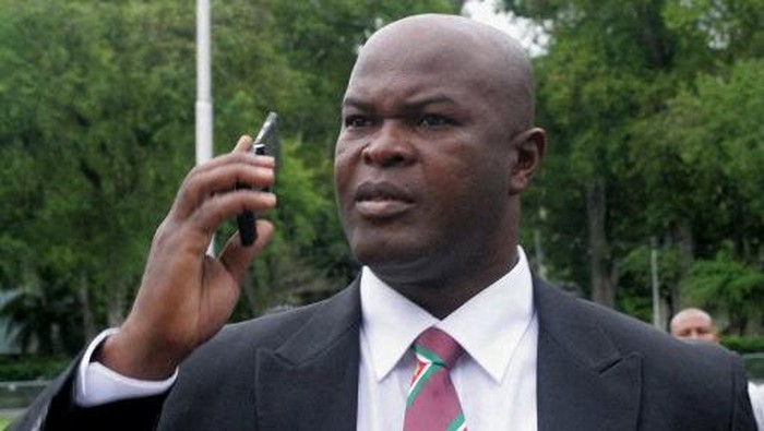 Ex-rebellion Ronnie Brunswijk speaks on the mobile phone on June 30, 2010 in Paramaribo. Brunswijk was among 50 people to be sworn in as member of Suriname parliament (DNA). President Ronald Venetiaan is the 51st member, but he has not accepted his invitation yet. Pro Bouterse supporters posted outside the parliament building protesting against the announcement of the opposing parties to push Paul Somohardjo forward for a second term as speaker of DNA. Police last night arrested Stanley Fernand, who with a group of fellow ex-soldiers, had threatened to kidnap Somohardjo. AFP PHOTO/Louis Alfaisie (Photo by Louis ALFAISIE / AFP)