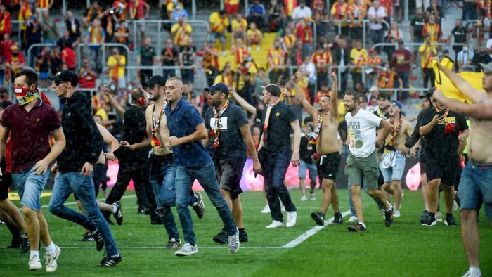 Lens supporters invade the pitch during the French L1 football match between RC Lens (RCL) and Lille (LOSC) at Stade Bollaert-Delelis in Lens, northern France, on September 18, 2021. (Photo by FRANCOIS LO PRESTI / AFP)