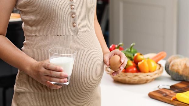 Ilustrasi ibu hamil makan telur dan minum susu