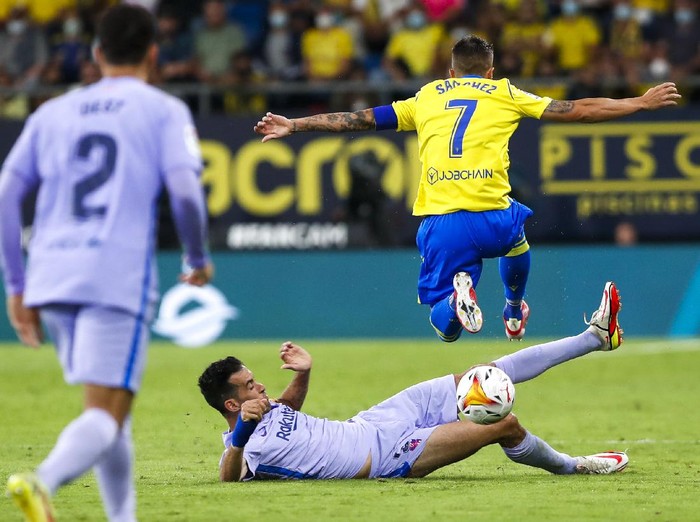 Barcelonas Sergio Busquets tackles Cadizs Salvi Sanchez during a Spanish La Liga soccer match between Cadiz and Barcelona at the Nuevo Mirandilla stadium in Cadiz, Spain, Thursday, Sept. 23, 2021. (AP Photo/Miguel Morenatti)