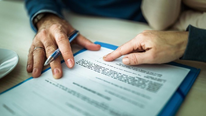 Close up of signing a mortgage contract in the office.