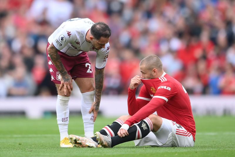 MANCHESTER, ENGLAND - SEPTEMBER 25: An injured Luke Shaw of Manchester United is checked on by Matty Cash of Aston Villa during the Premier League match between Manchester United and Aston Villa at Old Trafford on September 25, 2021 in Manchester, England. (Photo by Laurence Griffiths/Getty Images)
