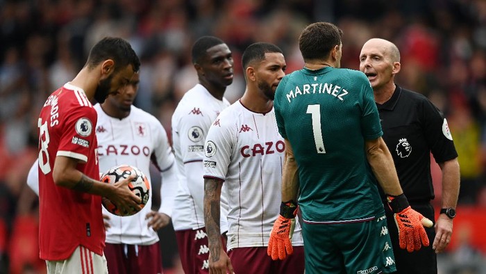 MANCHESTER, ENGLAND - SEPTEMBER 25: Referee Mike Dean speaks to Emiliano Martinez of Aston Villa  during the Premier League match between Manchester United and Aston Villa at Old Trafford on September 25, 2021 in Manchester, England. (Photo by Gareth Copley/Getty Images)