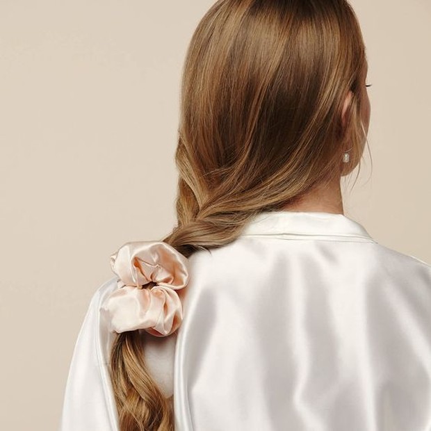 Padukan hairstyle side braid dengan silky scrunchy.