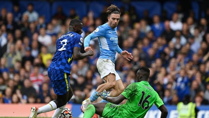 LONDON, ENGLAND - SEPTEMBER 25: Jack Grealish of Manchester City is challenged by Antonio Ruediger and Edouard Mendy of Chelsea during the Premier League match between Chelsea and Manchester City at Stamford Bridge on September 25, 2021 in London, England. (Photo by Shaun Botterill/Getty Images)