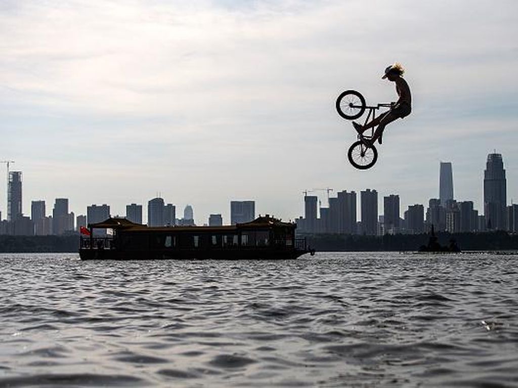 Unik Banget, Warga Wuhan Lompat ke Danau Naik Sepeda-Skuter