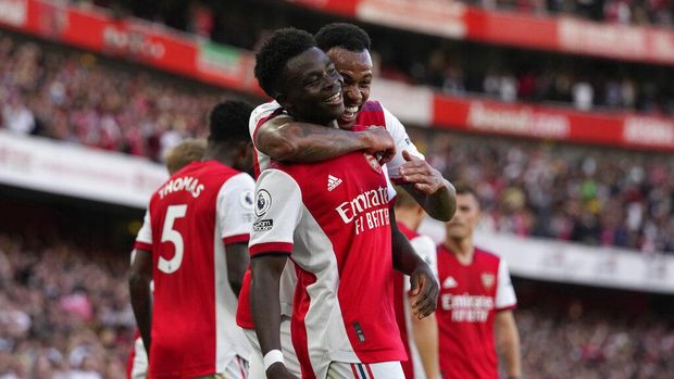 Arsenal's Bukayo Saka, center, celebrates after scoring his side's third goal during the English Premier League soccer match between Arsenal and Tottenham Hotspur at the Emirates stadium in London, Sunday, Sept. 26, 2021. (AP Photo/Frank Augstein)