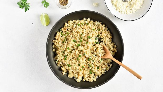 Roasted cauliflower rice on light stone background with free text space. Top view, flat lay
