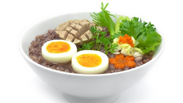sama bubur beras merah Rice Porridge Served Boiled Egg and Vietnames Saucesage decorate with carved carrots and vegetable sideview