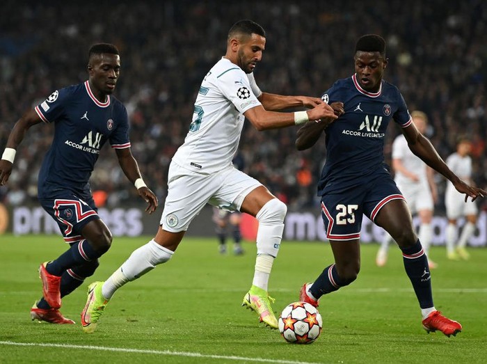PARIS, FRANCE - SEPTEMBER 28: Riyad Mahrez of Manchester City runs with the ball whilst under pressure from Nuno Mendes of Paris Saint-Germain during the UEFA Champions League group A match between Paris Saint-Germain and Manchester City at Parc des Princes on September 28, 2021 in Paris, France. (Photo by Shaun Botterill/Getty Images)