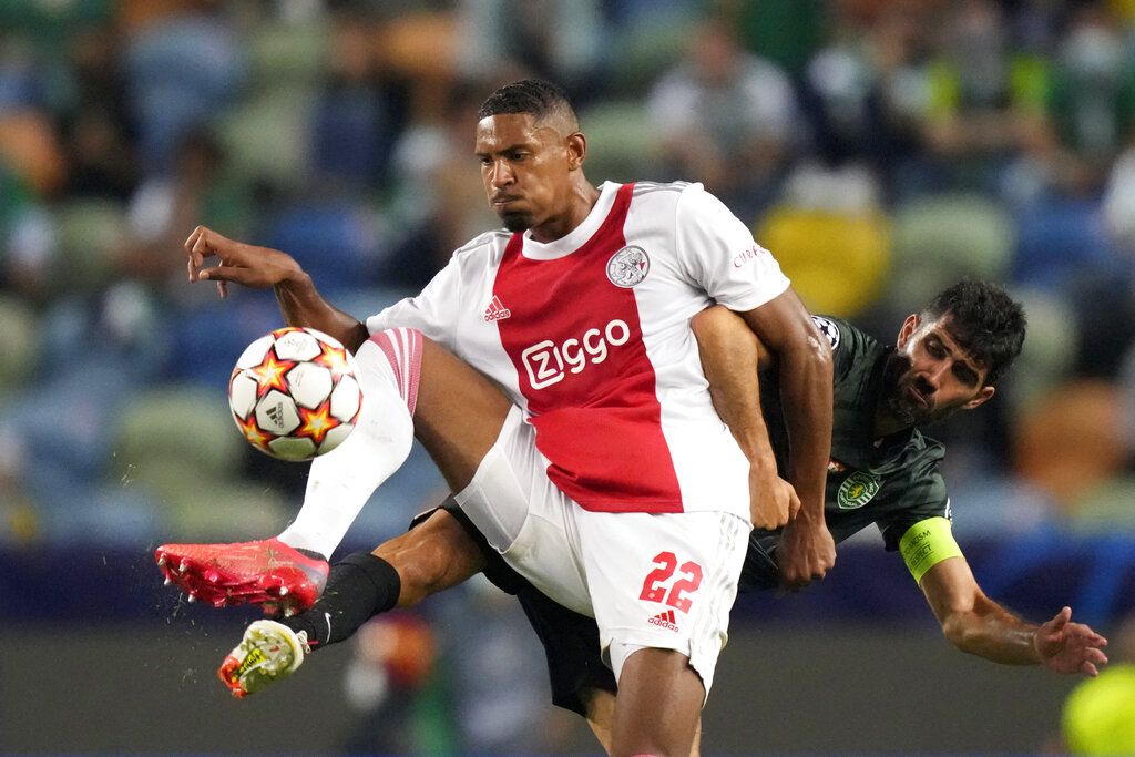 Sporting's Luis Neto, right, vies for the ball with Ajax's Sebastien Haller during a Champions League, Group C soccer match between Sporting CP and Ajax at the Alvalade stadium in Lisbon, Wednesday, Sept. 15, 2021. (AP Photo/Armando Franca)