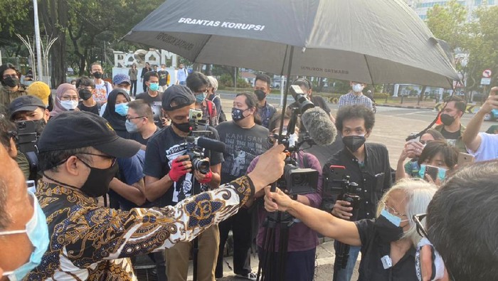 Momen Novel Baswedan dan Sumarsih memegang payung hitam di depan istana merdeka Momen Novel Baswedan dan Sumarsih memegang payung hitam di depan istana merdeka