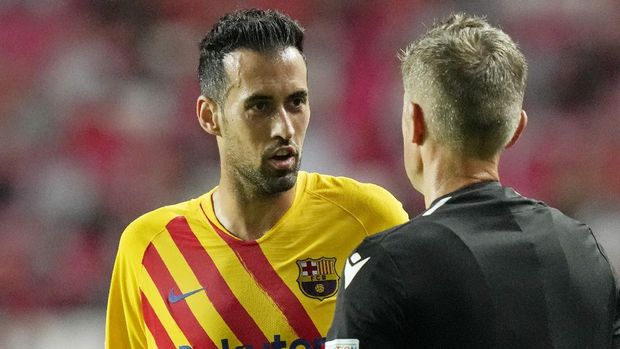 Barcelona's Sergio Busquets speaks with the referee during a Group E Champions League soccer match between Benfica and Barcelona at the Luz stadium in Lisbon, Portugal, Wednesday, Sept. 29, 2021. (AP Photo/Armando Franca)
