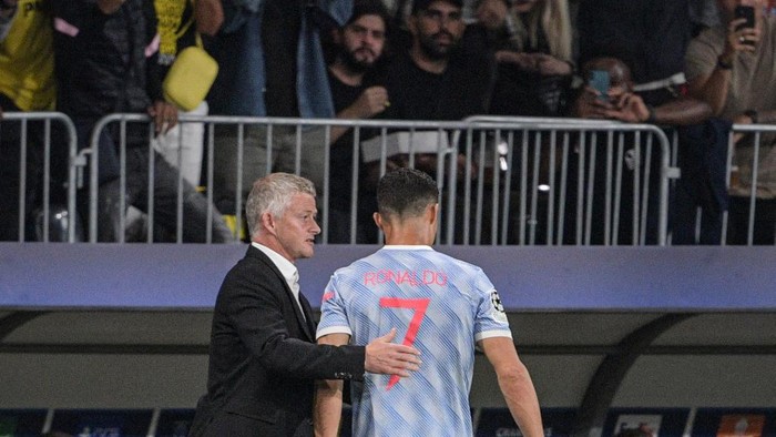 Manchester Uniteds Norwegian manager Ole Gunnar Solskjaer (L) speaks with Manchester Uniteds Portuguese striker Cristiano Ronaldo as he leaves the field following a substitution during the UEFA Champions League Group F football match between Young Boys and Manchester United at Wankdorf stadium in Bern, on September 14, 2021. (Photo by SEBASTIEN BOZON / AFP)