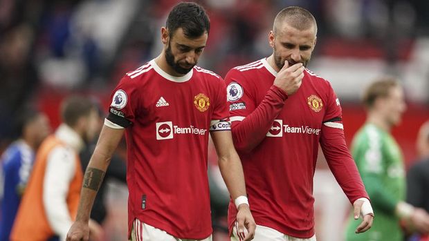 Manchester United's Bruno Fernandes, left, and Luke Shaw walk off the pitch at the end of the English Premier League soccer match between Manchester United and Everton, at Old Trafford, Manchester, England, Saturday, Oct. 2, 2021. The match ended in a 1-1 draw. (AP Photo/Dave Thompson)