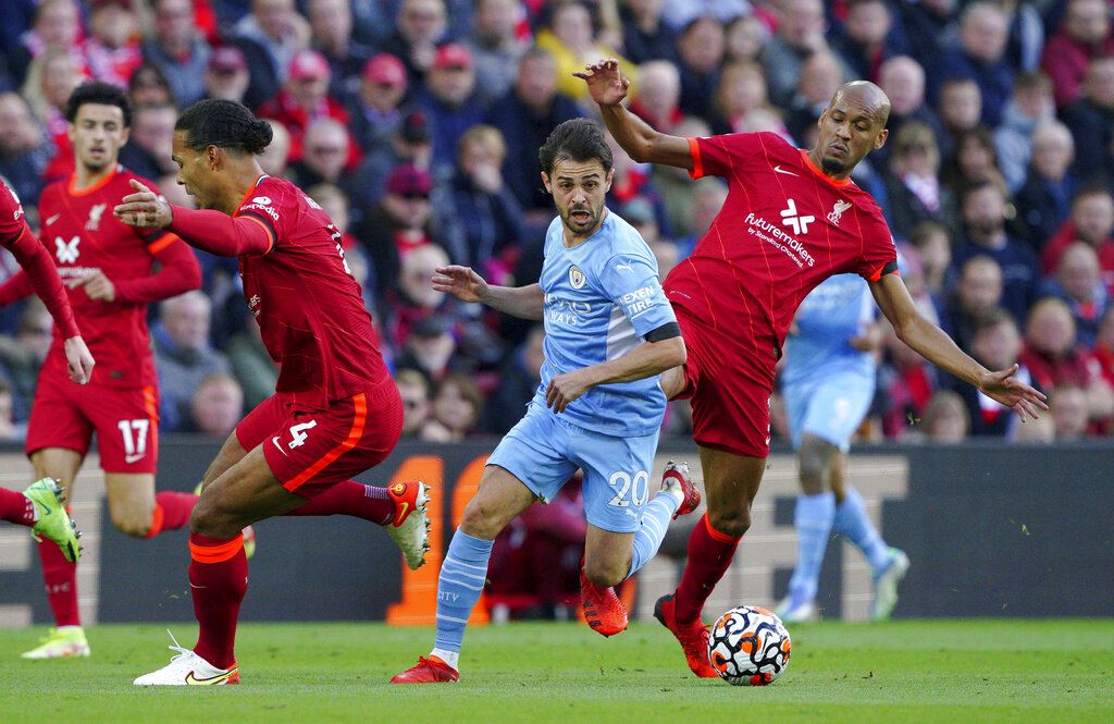Manchester City's Bernardo Silva, center, battles with Liverpool's Virgil van Dijk, left, and Fabinho during the English Premier League soccer match between Liverpool and Manchester City at Anfield, Liverpool, England, Sunday Oct. 3, 2021. (Peter Byrne/PA via AP)