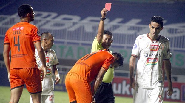 Wasit memberikan kartu merah kepada pesepak bola Persiraja Banda Aceh Muhammad Isa (tengah) setelah melakukan pelanggaran di kotak penalti Persija Jakarta dalam lanjutan laga Liga 1 di Stadion Pakansari, Kabupaten Bogor, Jawa Barat, Sabtu (2/10/2021). Persija Jakarta menang dengan skor 1-0.  ANTARA FOTO/Yulius Satria Wijaya/aww.
