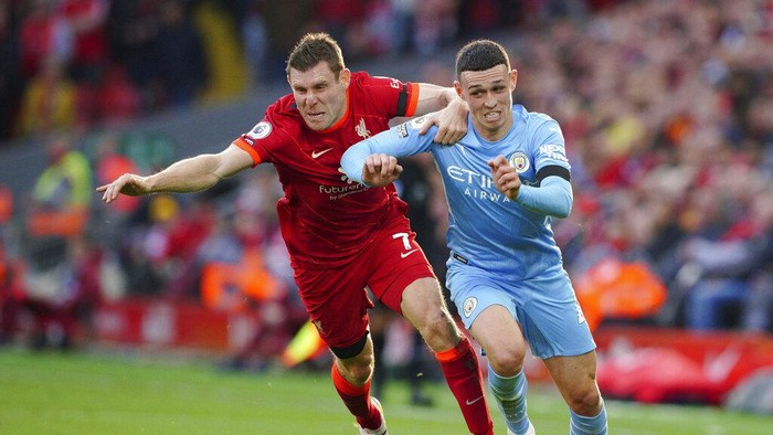 Liverpools James Milner, left, and Manchester Citys Phil Foden battle for the ball during the English Premier League soccer match between Liverpool and Manchester City at Anfield, Liverpool, England, Sunday Oct. 3, 2021. (Peter Byrne/PA via AP)