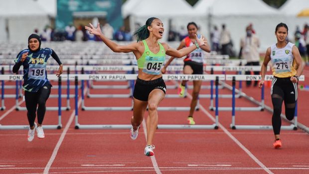 Pelari gawang DKI Jakarta Emilia Nova (045) melakukan selebrasi seusai finish pertama pada final 100 meter lari gawang PON XX Papua di Stadion Atletik, Mimika Sport Complex, Selasa (5/10/2021). PB PON XX Papua / Rommy Pujianto