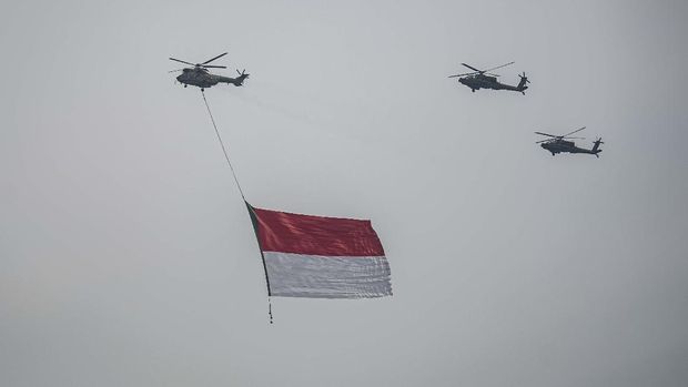 Tiga helikopter TNI terbang dengan mengibarkan bendera Merah Putih di kawasan Monas, Jakarta, Selasa (5/10/2021). Dalam rangka peringatan HUT Ke-76 Tentara Nasional Indonesia (TNI), sebanyak delapan pesawat helikopter TNI (AD, AL, AU) dengan call sign 