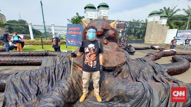 Organisasi pemerhati lingkungan, Greenpeace Indonesia menggelar aksi teatrikal dengan membawa replika hewan gurita berukuran besar ke depan gedung DPR-MPR pada Selasa (5/10).